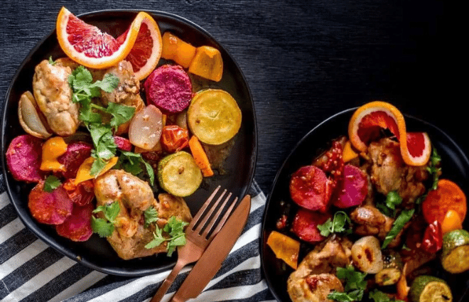 sheet pan chicken thighs with citrus chipotle glaze on two plates